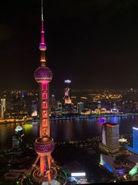 Illuminated buildings in city against sky at night