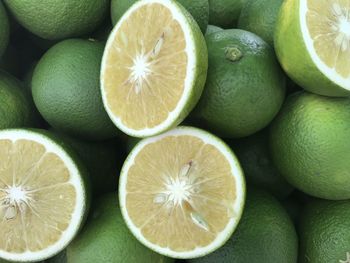 Fresh ripe sweet oranges which cut in a half and green oranges