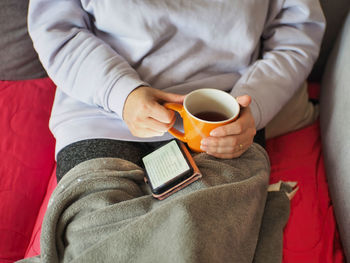 Midsection of woman holding coffee cup