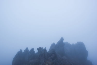 Rocks and trees against sky