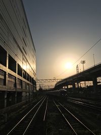 Railroad tracks against clear sky during sunset