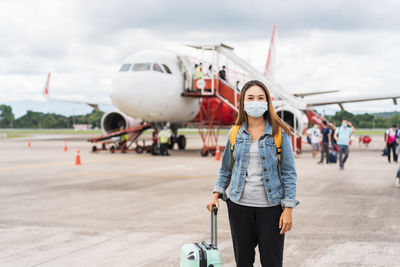 Portrait of woman wearing mask standing on airport