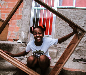 Portrait of smiling girl sitting on staircase