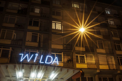 Low angle view of illuminated text on building at night
