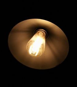 Low angle view of illuminated light bulb in the dark