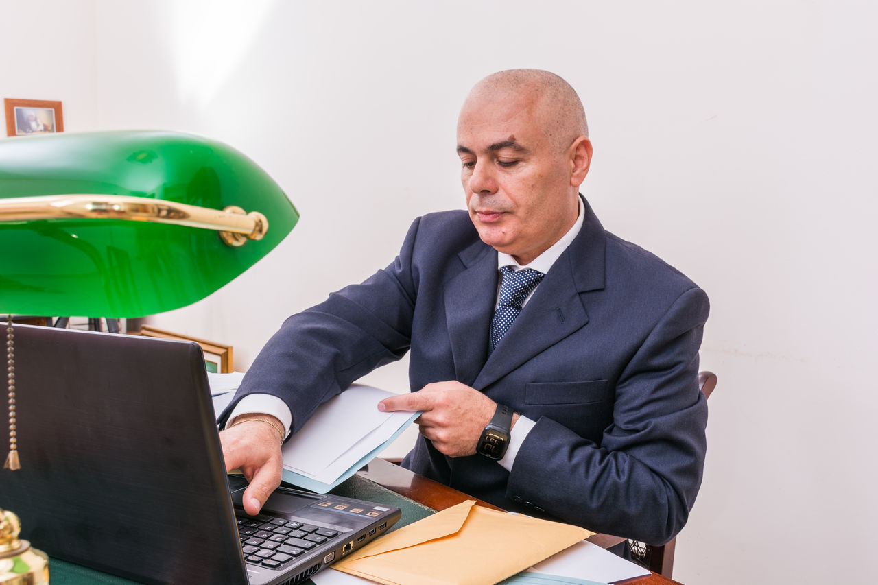 FULL LENGTH OF A MAN USING MOBILE PHONE IN LAPTOP