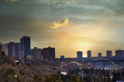 Buildings in city against sky during sunset