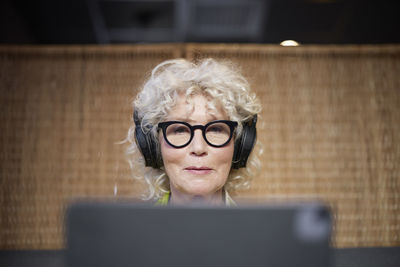 Senior woman with headphones using tablet