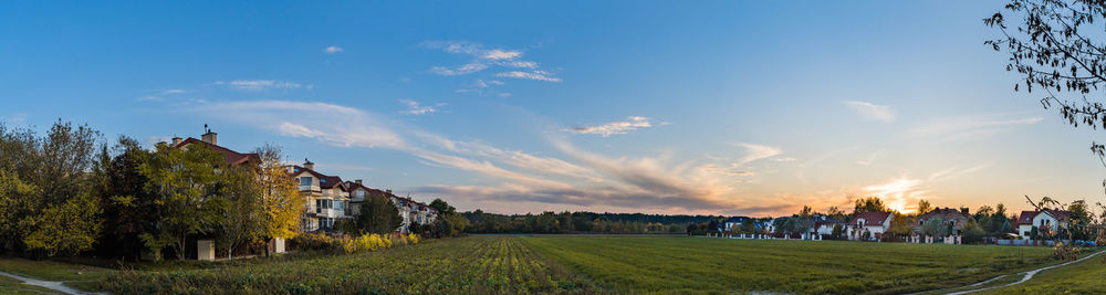 Panoramic view of trees and houses against sky during sunset