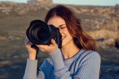 Portrait of woman holding camera