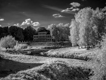 Mid distance view of mansion surrounded by trees against sky at uglich