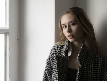 Portrait of young woman standing at home