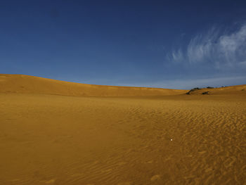 Scenic view of desert against blue sky