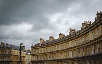 Low angle view of buildings against cloudy sky