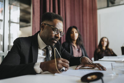 Mature businessman preparing strategy with colleagues in board room at office