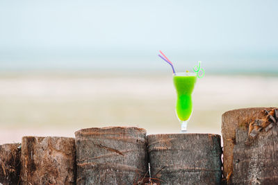 Close-up of drink at beach against sky