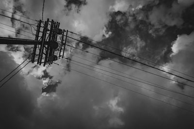 Low angle view of silhouette electricity pylon against sky