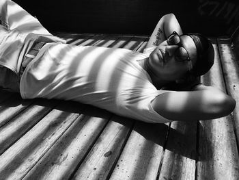 Man wearing sunglasses relaxing on boardwalk