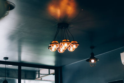 Low angle view of illuminated pendant lights hanging from ceiling