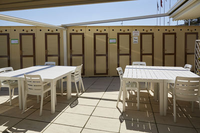 Empty chairs and tables against clear sky