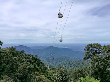 Overhead cable car over mountains against sky