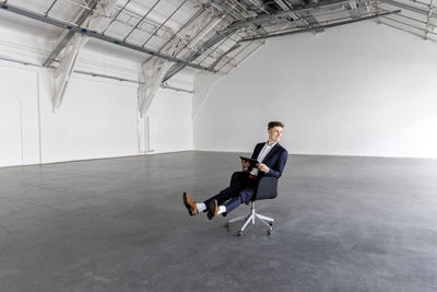 Businessman holding tablet pc on chair