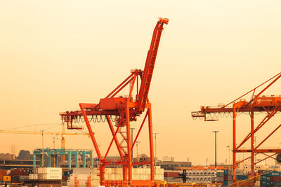 Cranes at construction site against clear sky