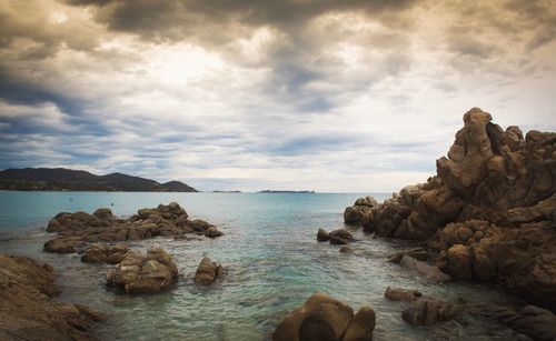 Rock formations by sea against sky