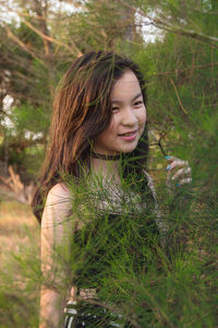 Smiling girl standing by branches