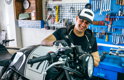 Mechanic with motorcycle at garage
