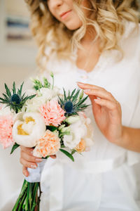 Midsection of woman holding flower bouquet