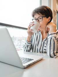 Business woman works with laptop and cup of coffee in co-working center. workplace for freelancers.