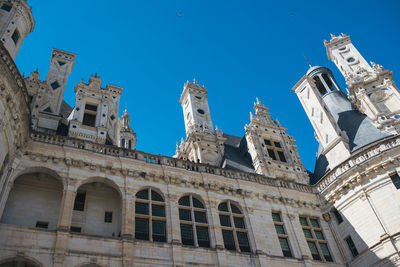 Low angle view of historical building against clear blue sky