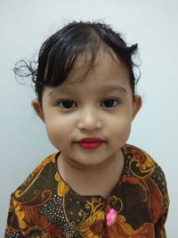 Portrait of cute girl against wall