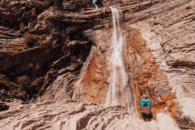 Rear view of woman against waterfall