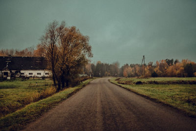 Road amidst field against sky