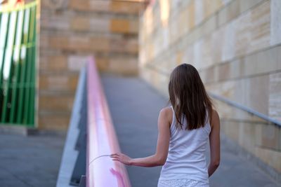 Rear view of woman standing against building