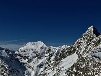 Scenic view of snowcapped mountains against clear blue sky