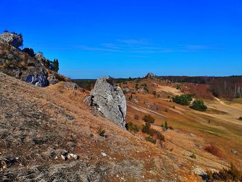 Rock formations on landscape against blue sky