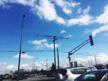 Cars on road against cloudy sky