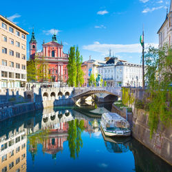 Arch bridge over river against buildings in city