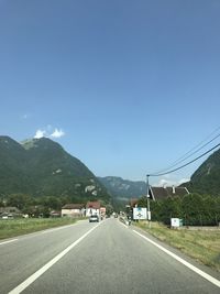 Road by mountain against blue sky