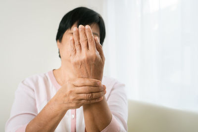 Portrait of man covering face with hands