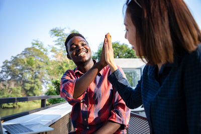 Young couple holding food against sky