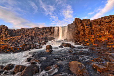 Low angle view of waterfall against sky