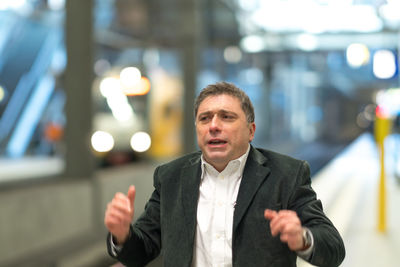 Thoughtful businessman standing at railroad station platform