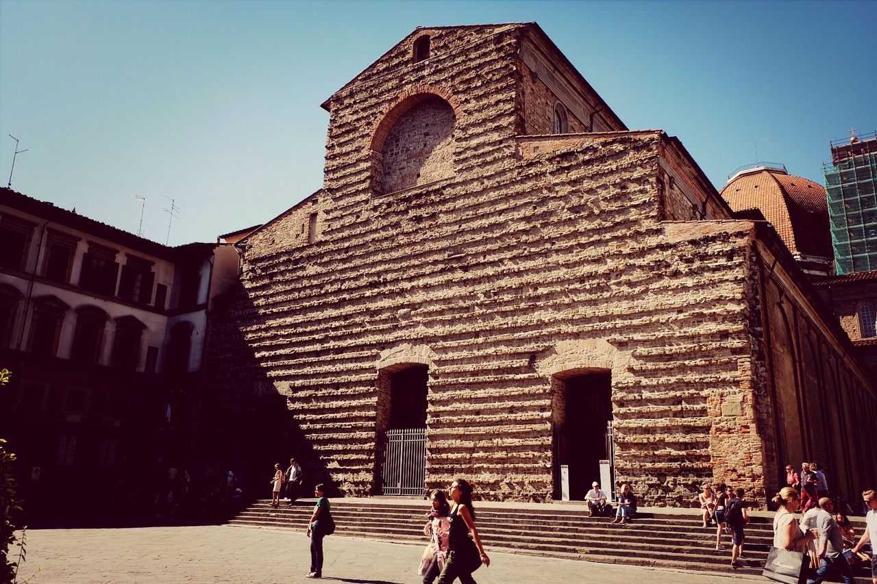 architecture, building exterior, built structure, person, men, lifestyles, walking, clear sky, history, leisure activity, sunlight, travel destinations, large group of people, shadow, travel, facade, famous place, steps, place of worship