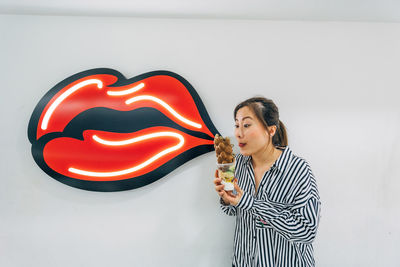 Woman looking at food against wall