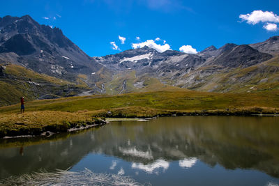 Scenic view of lake by mountains against sky