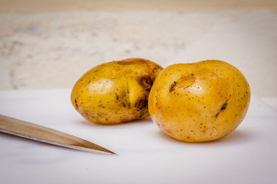 Close-up of knife and potatoes on cutting board